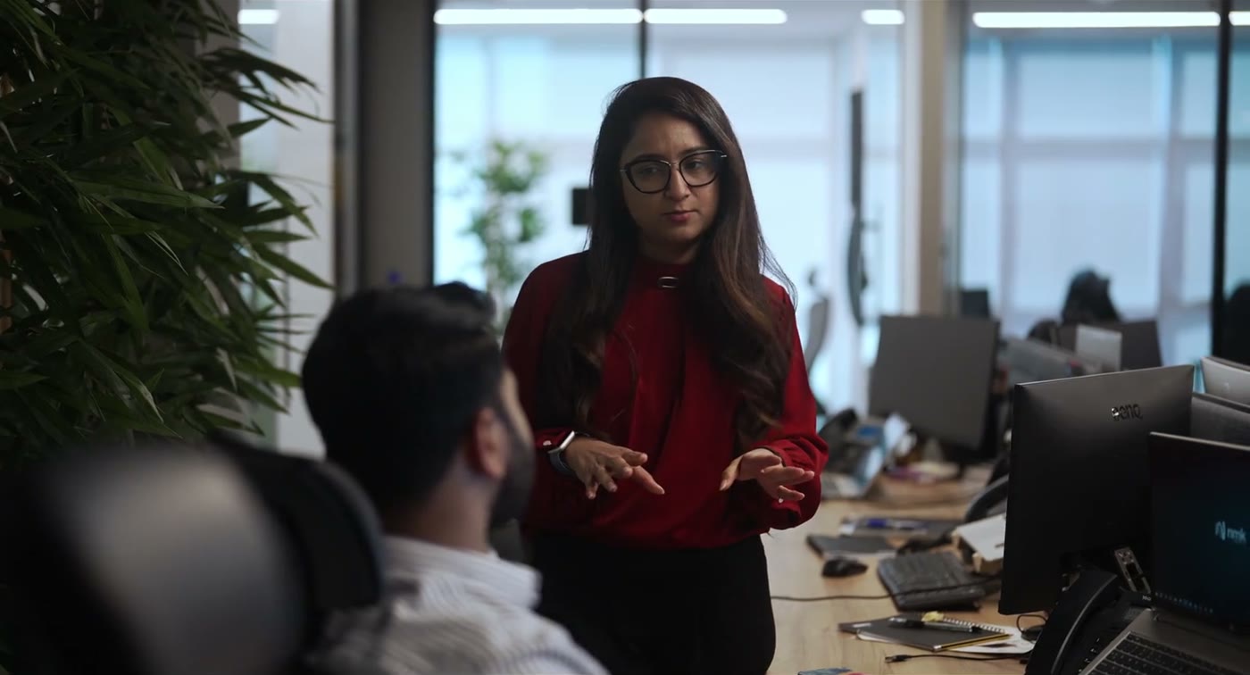 Executive presenting to a colleague in a modern office — corporate film still